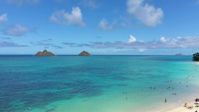 Aerial view of the twin Mokulua Islands off the coast of Lanikai beach in Oahu, Hawaii, with turquoise water and visible coral reefs in the foreground.