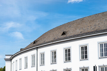 The Large round roof is covered with the flat tile of an old house with two triangular windows in the attic.