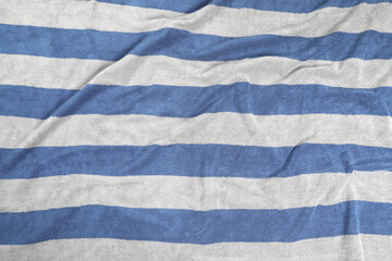 Crumpled striped beach towel as background, top view