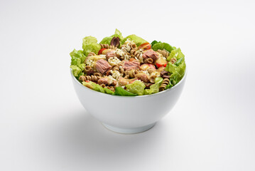 Fresh tuna, pasta and ricotta cheese salad, with dressing, in white bowl, isolated