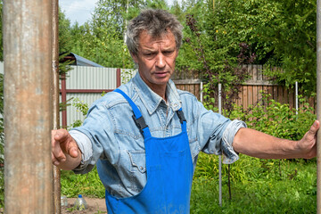 Man is a builder on a real construction site in nature. Construction of a house.