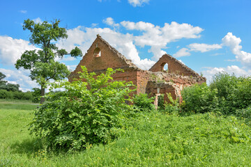 abandoned red brick estate surrounded by greenery against the background of the sky