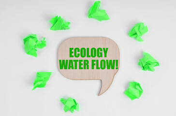 On a white background, crumpled green pieces of paper and a wooden sign with the inscription - Ecology Water Flow.