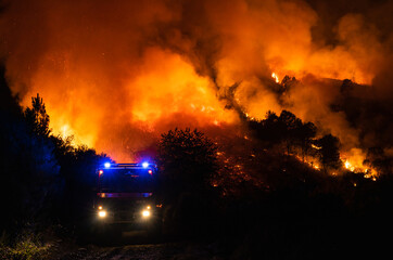 Un camión de bomberos delante de las llamas en un incendio forestal en Galicia, España. 