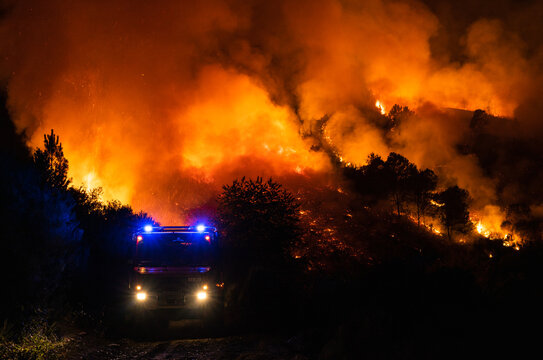 Un cami&oacute;n de bomberos delante de las llamas en un incendio forestal en Galicia, Espa&ntilde;a. 