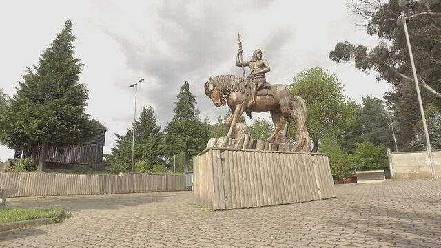 estatua de grurrero mapuche con fuerte de fondo
