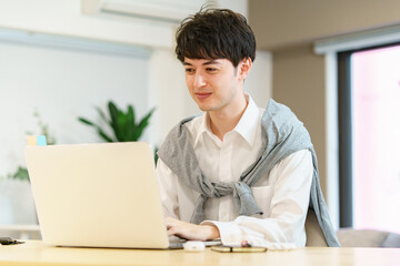 カジュアルな空間でノートパソコンを使う若い男性