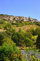 Fototapeta na wymiar Compeyre (12520) au delà des fleurs depuis Aguessac (12520), département de l'Aveyron en région Occitanie, France