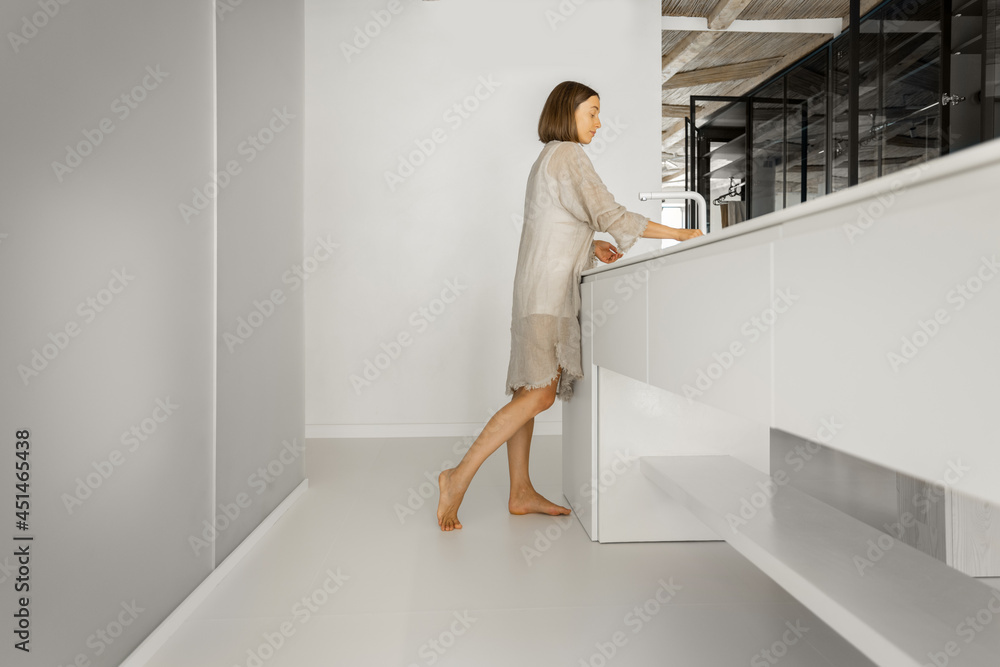 Wall mural Modern kitchen with motion blurred female person walking. Home coziness, cooking at home and modern interior