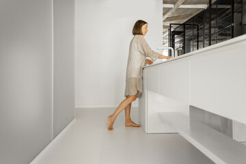 Modern kitchen with motion blurred female person walking. Home coziness, cooking at home and modern interior