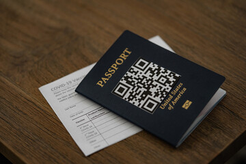 COVID-19 Vaccination Record card next to the Passport with QR Code. Vaccination Passport Travel concept.