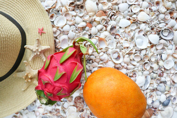 Exotic fruits. dragon fruit and mango on a background of seashells 