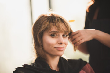 Fototapeta premium professional hairdresser stylist person and hair fashion beauty salon concept, woman client about haircut and hair care, coiffure barber equipment, hairstylist work to making hairstyle to woman model