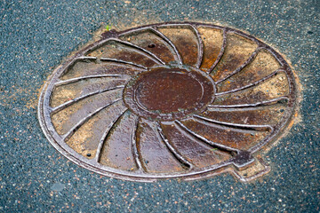Metal covers of sewer manholes on city roads close-up.