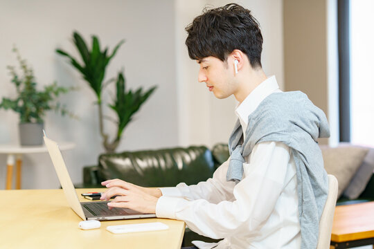 カジュアルな空間でノートパソコンを使う若い男性