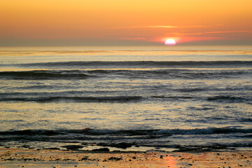 Sun setting on the horizon over the Pacific Ocean in California.