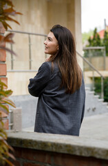 the young girl walks around the city, posing from behind.