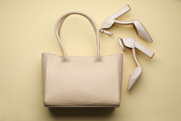 Stylish woman's bag and shoes on beige background, flat lay