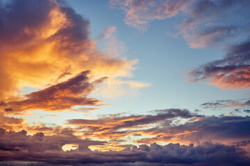 A cloud illuminated by a sun in the evening sky at sunset