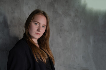 Fototapeta premium portrait of confident serious brunette woman in black clothes on dark background. femininity