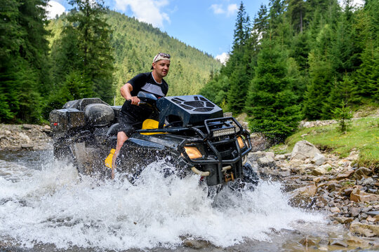 ATV racing on on mountain river  track at summer mountain