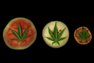 Red grapefruit and red and yellow water melon with leaf of marijuana flower