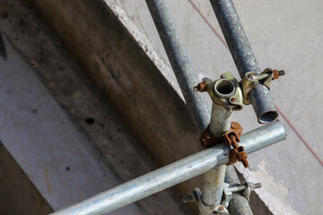 Closeup of metal steel bars screwed together by screws and nuts. Safety handrails on construction building site