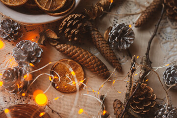 Christmas New Year top view of handmade crafts with pine cones, dry round slices of oranges, garland, branches. New year holiday, celebration concept. Flatlay