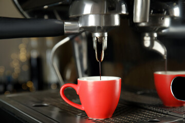 Making fresh aromatic espresso using professional coffee machine