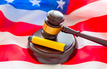 brown gavel and electronic cigarette on the background of the American flag, concept of danger and...