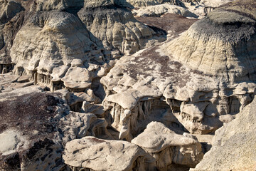 Cap stones create shelves for hikers to traverse in the Bisti Badlands