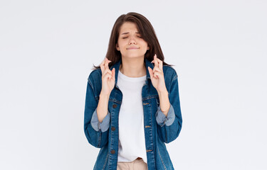 Young woman crossing her fingers and wishing for good luck