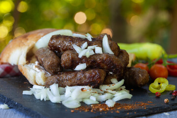 Grilled kebab, turkish style barbecued minced meat with onion. Traditional Balkan food - cevapi or...
