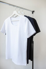 Women's clothing. Women's T-shirts hang on a hanger in the store. Blue, white, black