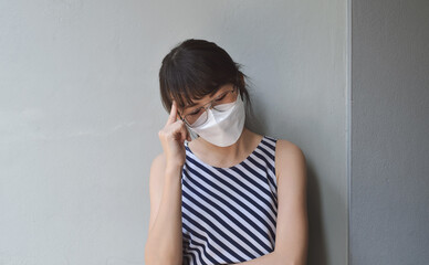 Asian women Portrait  wearing mask and has headache.