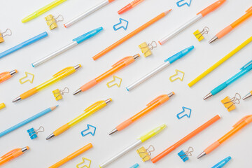 Flat lay pattern with school and office supplies on a white background