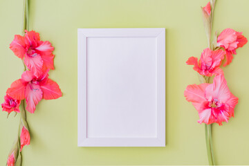 Mockup with a white frame and pink flowers on a green background