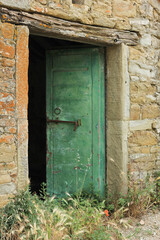 Antique open green door in a Tuscan house