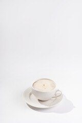 A white porcelain cup with coffee drink cappuccino on a white saucer plate on a white surface