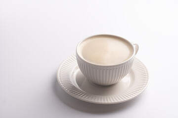 A white porcelain cup with coffee drink cappuccino on a white saucer plate on a white surface
