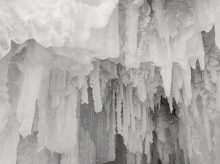 snow icicles and winter patterns on the rocks in the cave