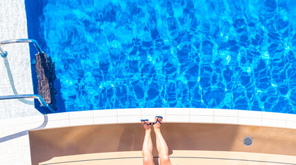 Vue de jambes d'un homme au bord d'une piscine.
