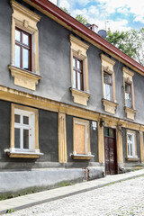 KRAKOW,POLAND - AUGUST 17, 2021: Historic townhouses along a steep cobblestone street in Krakow, Poland.