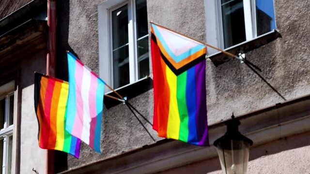Multi-colored lgbt flag on the building of the house. LGBT gay pride flag waving in the wind. Concept for lesbian, gay, bisexual, transgender, homosexual, pride parade street party celebration