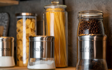 Obraz na płótnie Canvas pasta, spaghetti, sugar, salt and coffee in different containers on the shelf
