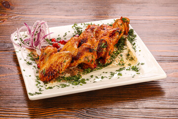 Roasted chicken wings served onion