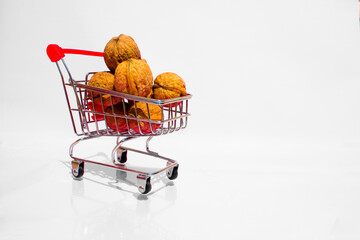 A small cart full of walnuts on a white background