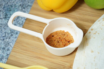 Spice mix coconut curry in measuring cups lie on wooden board
