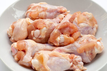 Fresh raw chicken wings (wingstick) in white plate on white background.