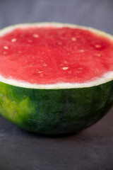 half ripe watermelon on a dark background